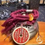 A set of protection amulets designed as a red string bracelet for the wrist. These unique protection amulets feature a detailed Mountain Spirit amulet coin for spiritual safety. Amulet of proof against detection and location, blessed by Taoist Master. Amulet protection from ghost and negative energy.